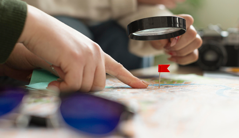 Team looking over a map with a magnifying glass